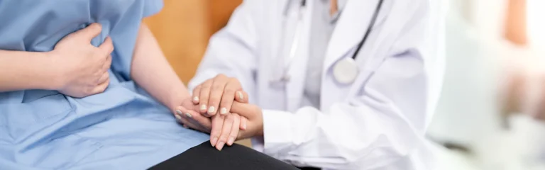 female nurse hold her migrant patients hand giving support